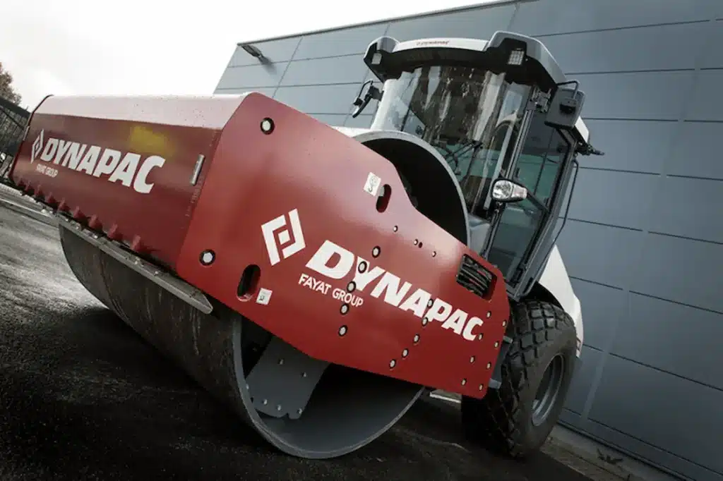 Close-up of a Dynapac road roller parked outside an industrial building