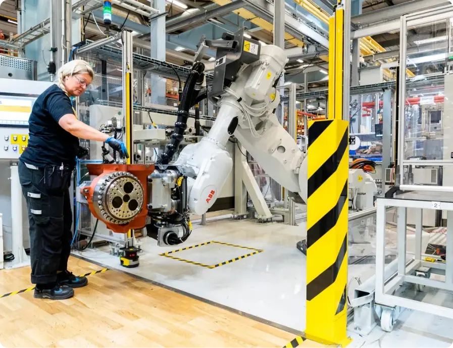 Technician working with an industrial robot arm in a modern factory environment
