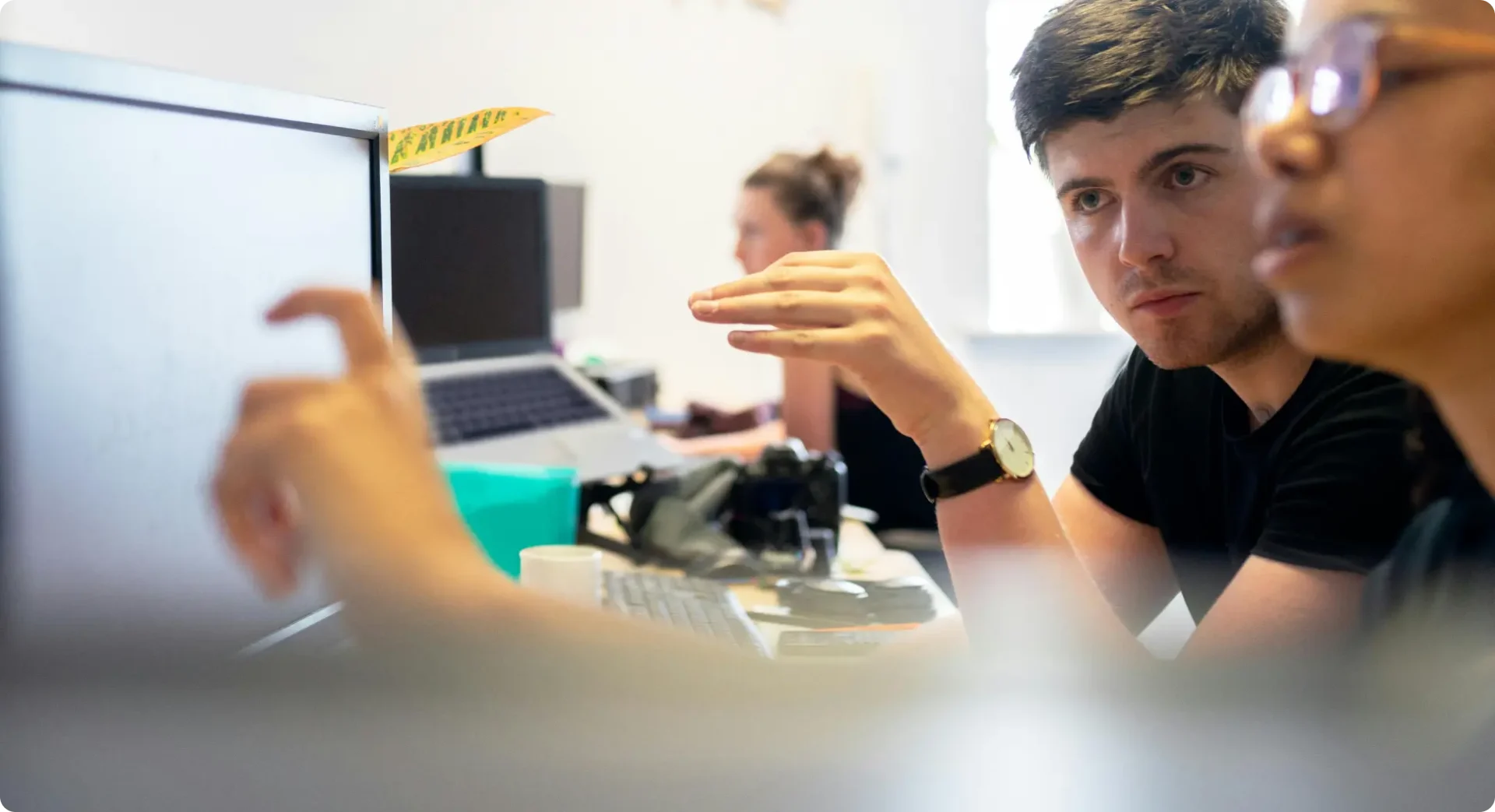 People in an office environment with screens and devices