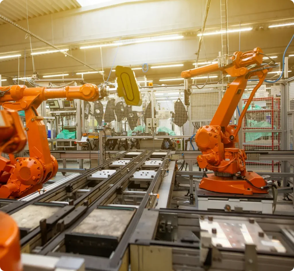 Orange robot arms in a modern factory environment