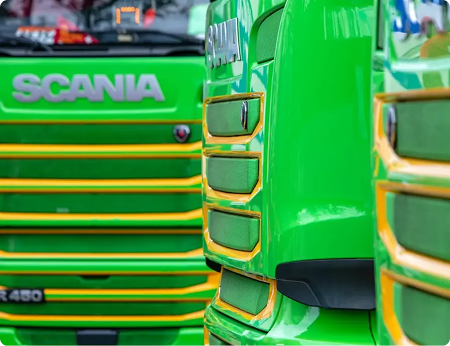 Close-up of green Scania trucks