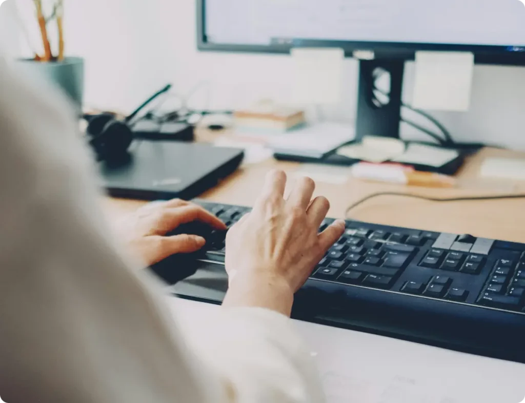 Close-up of hands typing on a keyboard