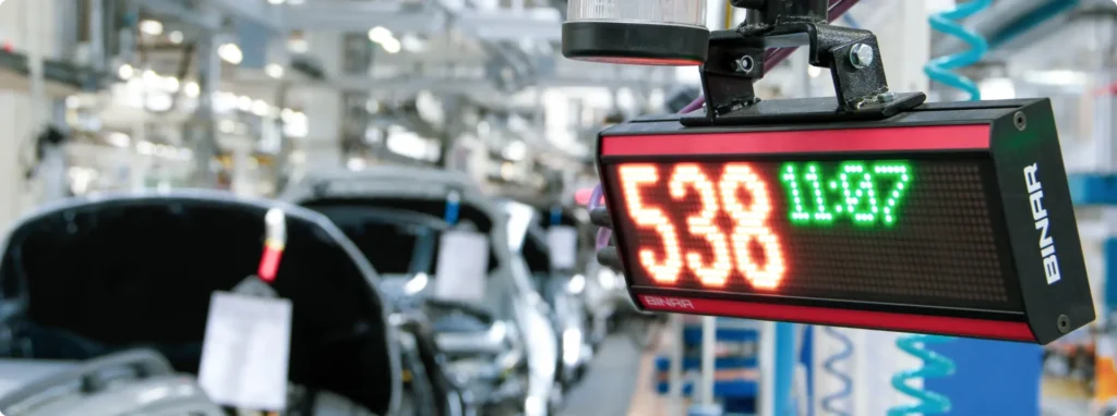 Binar LED display showing a number and time in an automotive factory environment