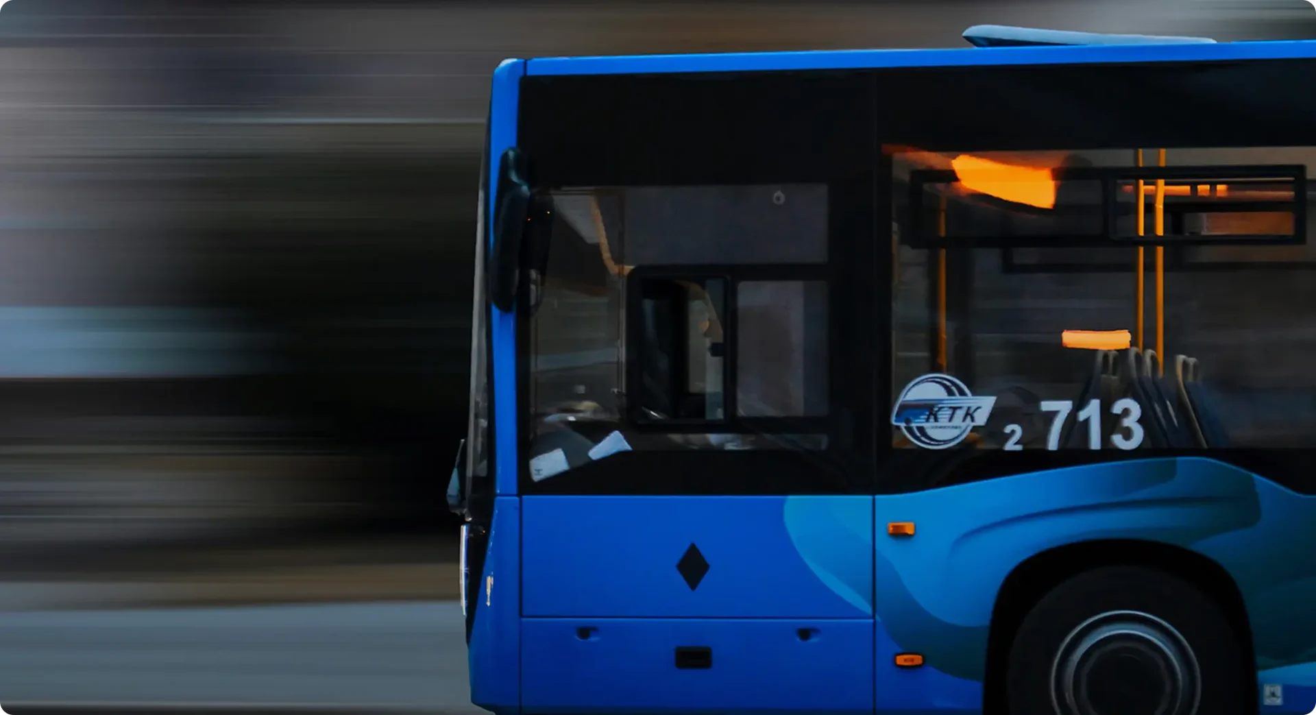 Close-up of a blue bus driving fast
